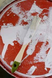 A bucket of white paint to be used to paint stair balusters.