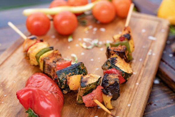 Wooden sticks for food, holding vegetables on a wood cutting board.