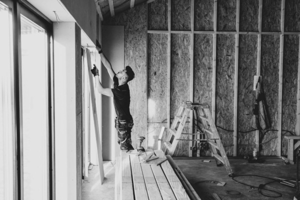 Man doing construction work inside house.