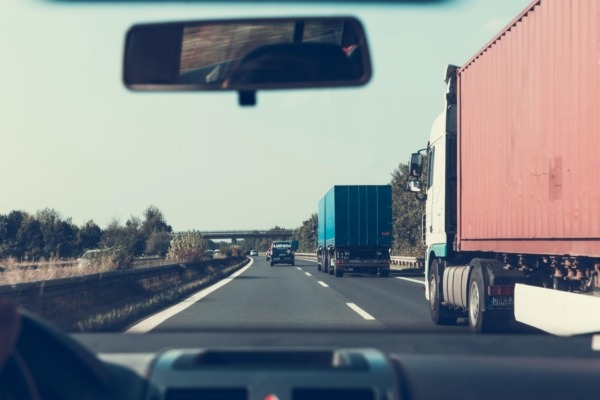 Blue and red freight truck on road.