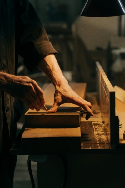 A woodworker working on a piece in a shop.